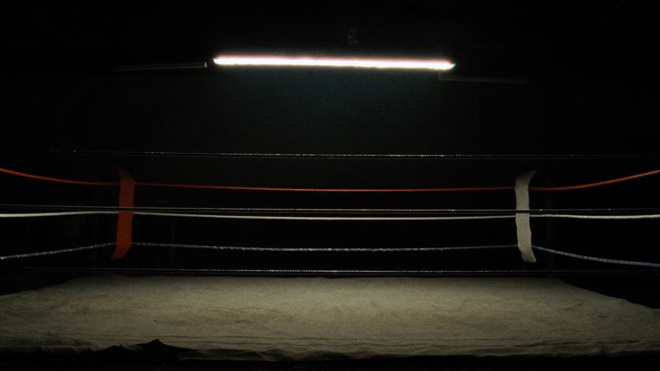 Scout frame: an empty boxing ring under one work light